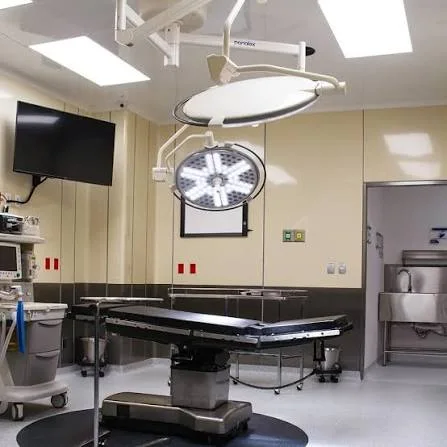 Sala quirúrgica equipada con mesa y lámparas de cirugía